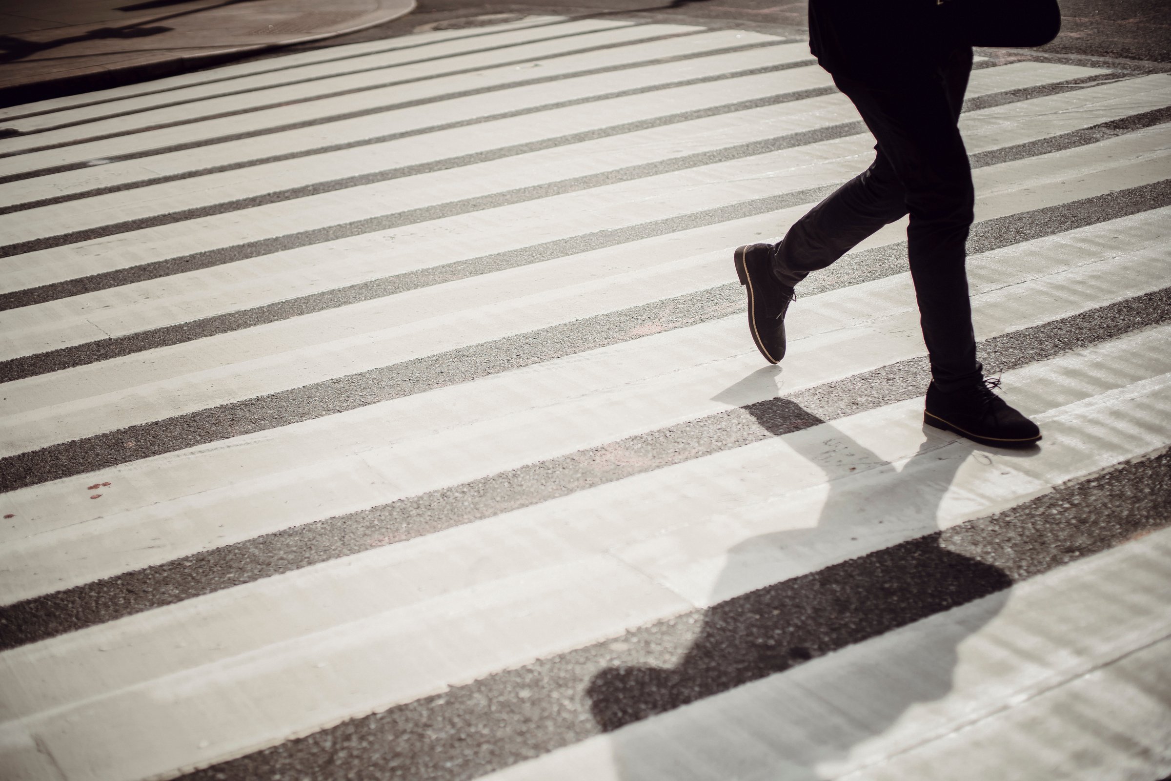 Anonymous pedestrian walking on zebra crossing